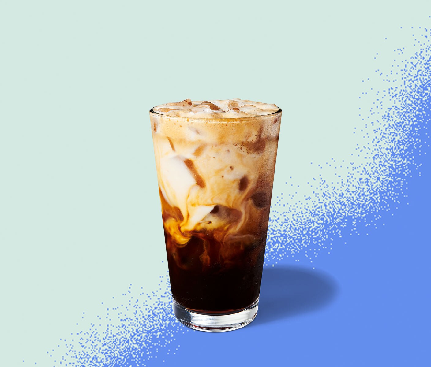 Iced espresso drink with creamy marbling in a tall glass.
